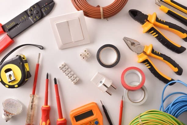 Tools and electrical material on a white table general view Horizontal composition. Top view.